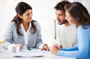 Couple looking at papers with real estate agent